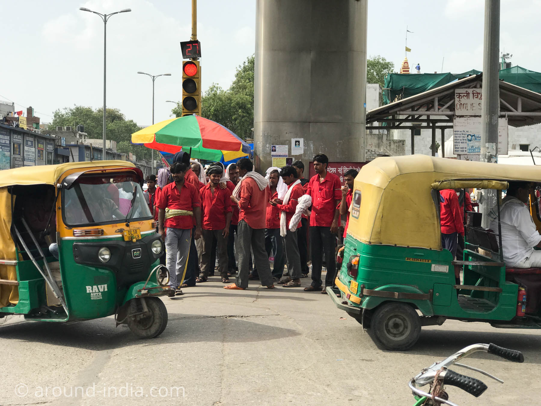 インド・ニューデリー駅の到着するオートリキシャのお客さんを狙うポーター